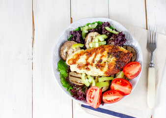 Homemade grilled halloumi cheese with spices on wooden board with fresh vegetables
