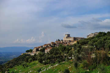The view of an ancient Italian town Sermoneta from far away, with field and mountains in the background