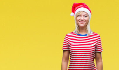 Young beautiful blonde woman wearing christmas hat over isolated background with a happy and cool smile on face. Lucky person.