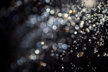 bokeh of water fly and lights on black background,