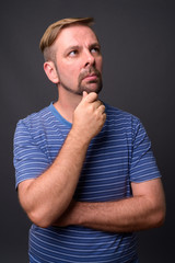 Blond bearded man with goatee against gray background