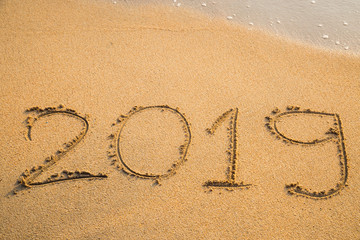 Abstract message Year 2019 written on beach sand
