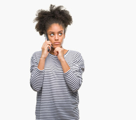 Fototapeta na wymiar Young afro american woman talking on the phone over isolated background serious face thinking about question, very confused idea