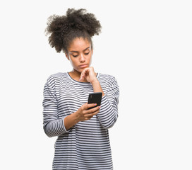 Young afro american woman texting using smartphone over isolated background serious face thinking...