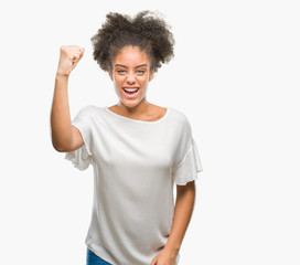 Young afro american woman over isolated background angry and mad raising fist frustrated and furious while shouting with anger. Rage and aggressive concept.