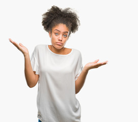 Young afro american woman over isolated background clueless and confused expression with arms and hands raised. Doubt concept.