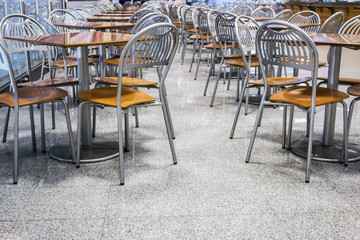 rows of metal chairs and tables in an outdoor cafe