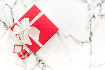 Top view of red gift box and red ribbon on white marble background with space.Christmas and New year day