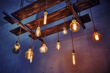 Vintage incandescent lamps mounted on a wooden ceiling structure. Christmas festive decoration