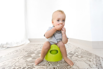 Baby sitting on potty at home interior
