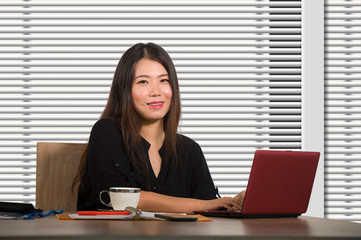 young beautiful and successful Asian Chinese business woman working confident at modern office computer desk in female businesswoman success