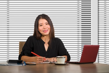 young beautiful and successful Asian Chinese business woman working confident at modern office computer desk in female businesswoman success