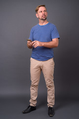 Blond bearded man with goatee against gray background