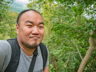 Portrait photo of Asian Tourist trekking to the top of Khao Luang mountain in Ramkhamhaeng National Park,Sukhothai province Thailand