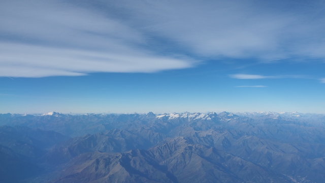 Fototapeta Flying over the European Alps during fall season. Aerial view from the airplane window