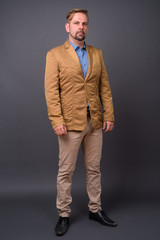 Blond bearded businessman with goatee against gray background