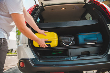 Fototapeta na wymiar hands load bags in car trunk