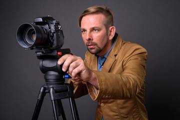 Blond bearded businessman with goatee against gray background