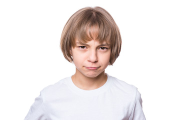Sad attractive caucasian girl, isolated on white background. Unhappy schoolgirl looking at camera. Child in white t-shirt - emotional portrait close-up.