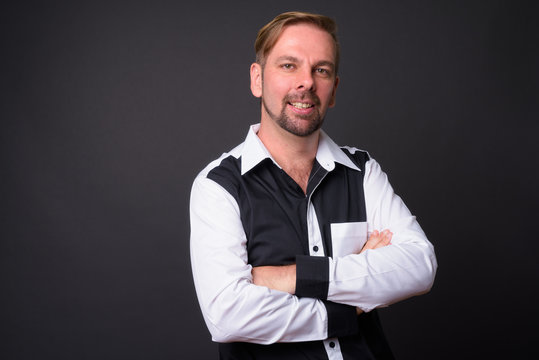 Blond bearded businessman with goatee against gray background