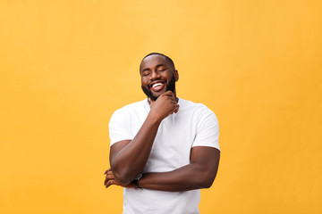 Portrait of a modern young black man smiling with arms crossed on isolated yellow background