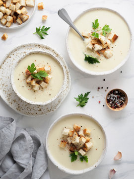 cauliflower potato soup puree on white marble tabletop, Creamy cauliflower soup with toasted bread croutons. Vegetarian healthy food concept. Ideas and recipes for winter meal. Top view or flat lay