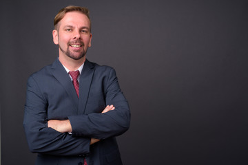 Blond bearded businessman with goatee against gray background