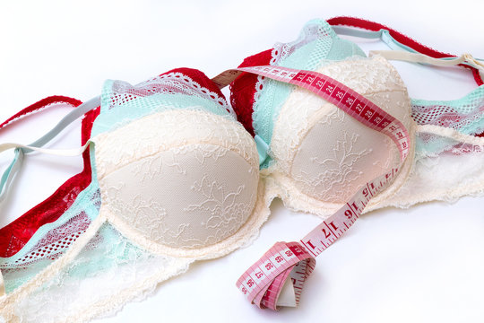 Beige push up bra with a bottle of perfume and white rose on soft cloth