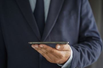 Business man hold the smartphone on the street  and copy space.
