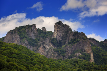 Naklejka premium Clouds over the tops of the rocky mountains. Photographed in the Caucasus, Russia.