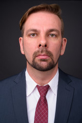 Blond bearded businessman with goatee against gray background