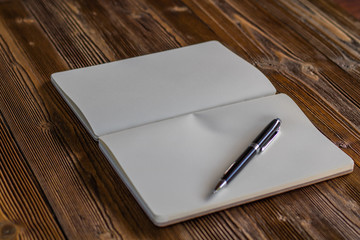 Book and pen open  on wood background. Top view.Vintage style.