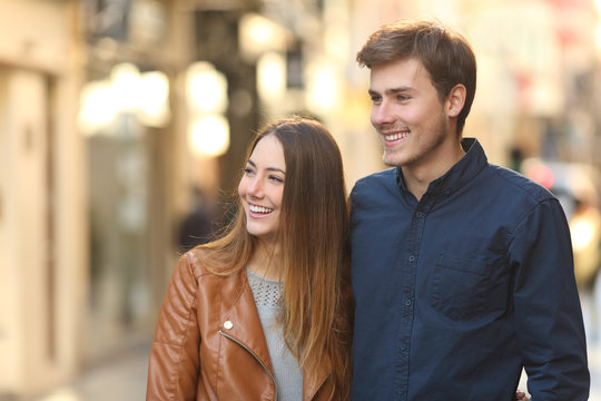 Happy Couple Dating Walking In The Street Looking At Side