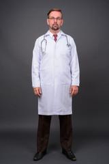 Blond bearded man doctor with goatee against gray background