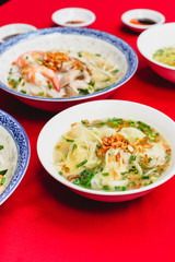 Set of Vietnamese Noodles with Pork and Shrimp Recipe soup bowl on the red carpet with sauce and green lemon