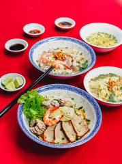 Set of Vietnamese Noodles with Pork and Shrimp Recipe soup bowl on the red carpet with sauce and green lemon