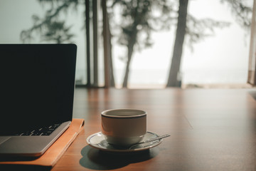 Laptop and coffee cup on wooden floor