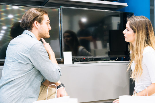 Young couple choosing a television in an appliance store
