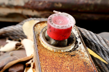 old rusty oil can with red lid close up