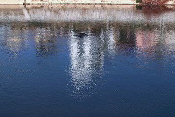Fototapeta premium background or wallpaper of water,reflecton of blue sky and white building in river on sunny day, copy space water texture