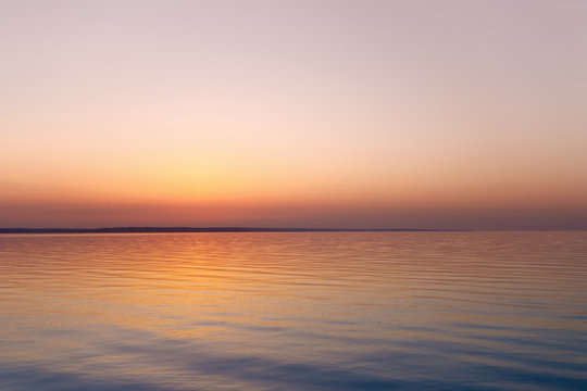 Fototapeta sunrise on the water / Early summer morning bright sky Beach