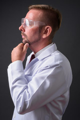 Blond bearded man doctor with goatee against gray background