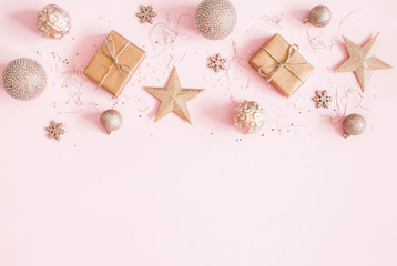Christmas composition. Christmas gifts, golden decorations on pastel pink background. Flat lay, top view, copy space
