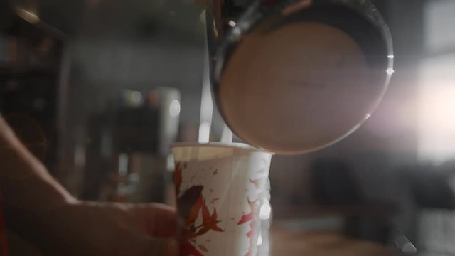 A man pours milk into a glass. Making coffee with you. Hands in sunlight close-up. 4K