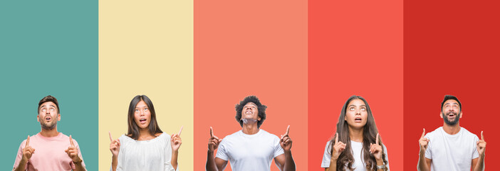 Fototapeta premium Collage of different ethnics young people over colorful stripes isolated background amazed and surprised looking up and pointing with fingers and raised arms.