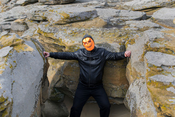 Man in a pumpkin mask in the mountains.
