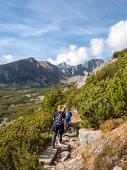 Obraz premium Hikers on trail at Great Cold Valley, Vysoke Tatry (High Tatras), Slovakia. The Great Cold Valley is 7 km long valley, very attractive for tourists