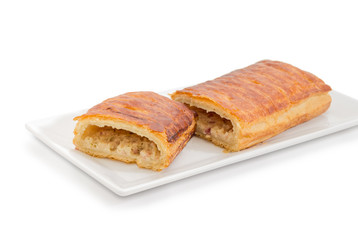 Pie with savory topping on a small rectangular dish