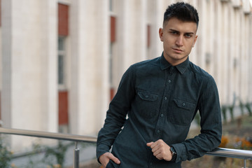 Portrait of a handsome young casual guy posing on street backgro