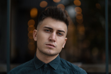 Young handsome man close up portrait with lights in background